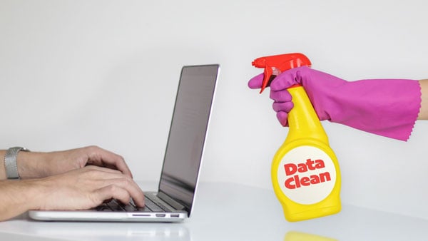 Spray bottle labeled Data Clean pointed at laptop