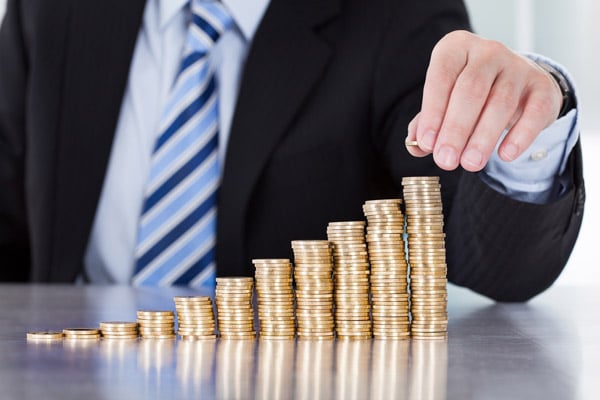 Business man stacking gold coins from low to high