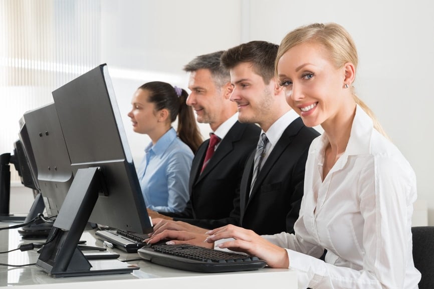 Group of people typing on their computer in a professional atmosphere