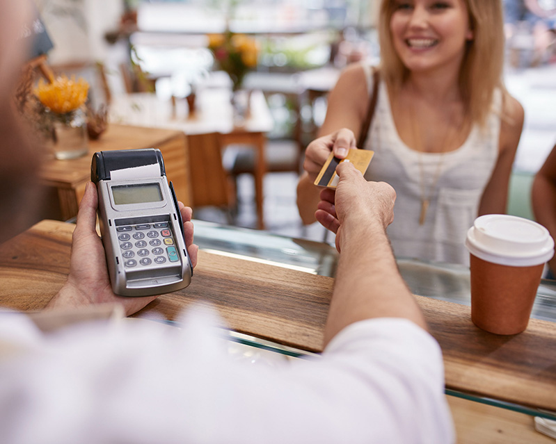 Woman handing over credit card to store clerk